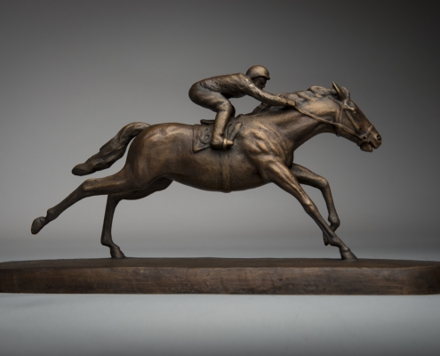 Bronze sculpture of a galloping racehorse with jockey