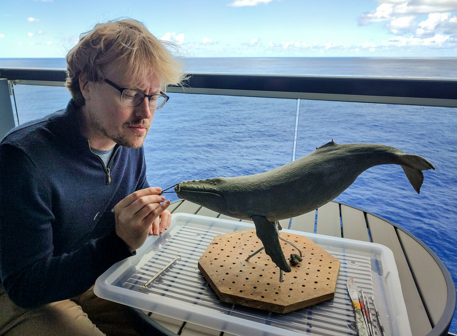 Wildlife artist Anthony Smith working on a sculpture of a Humpback Whale on board the luxury cruise ship Seabourn Ovation